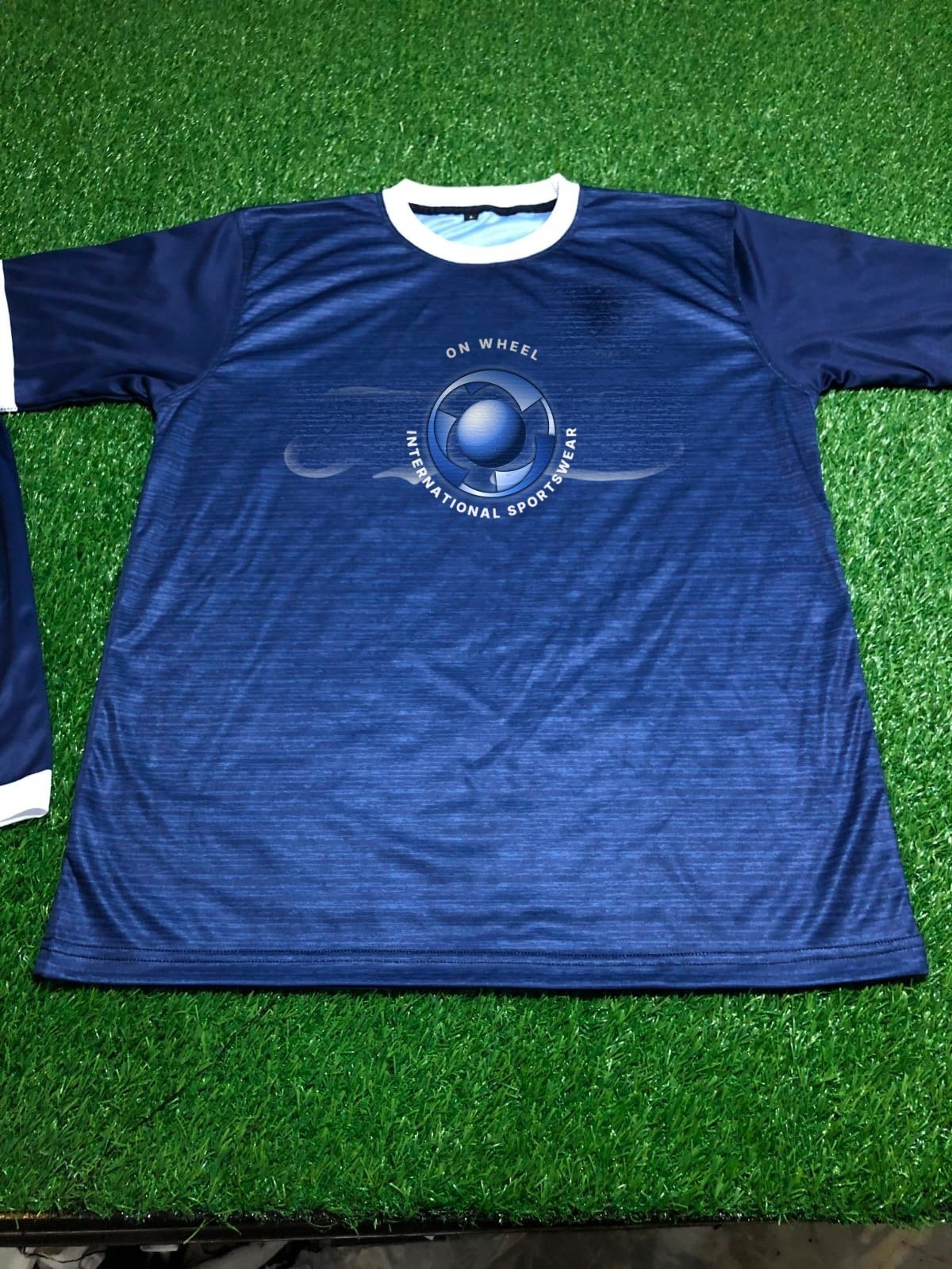 Sublimated navy football jersey laid flat, made by On Wheel International